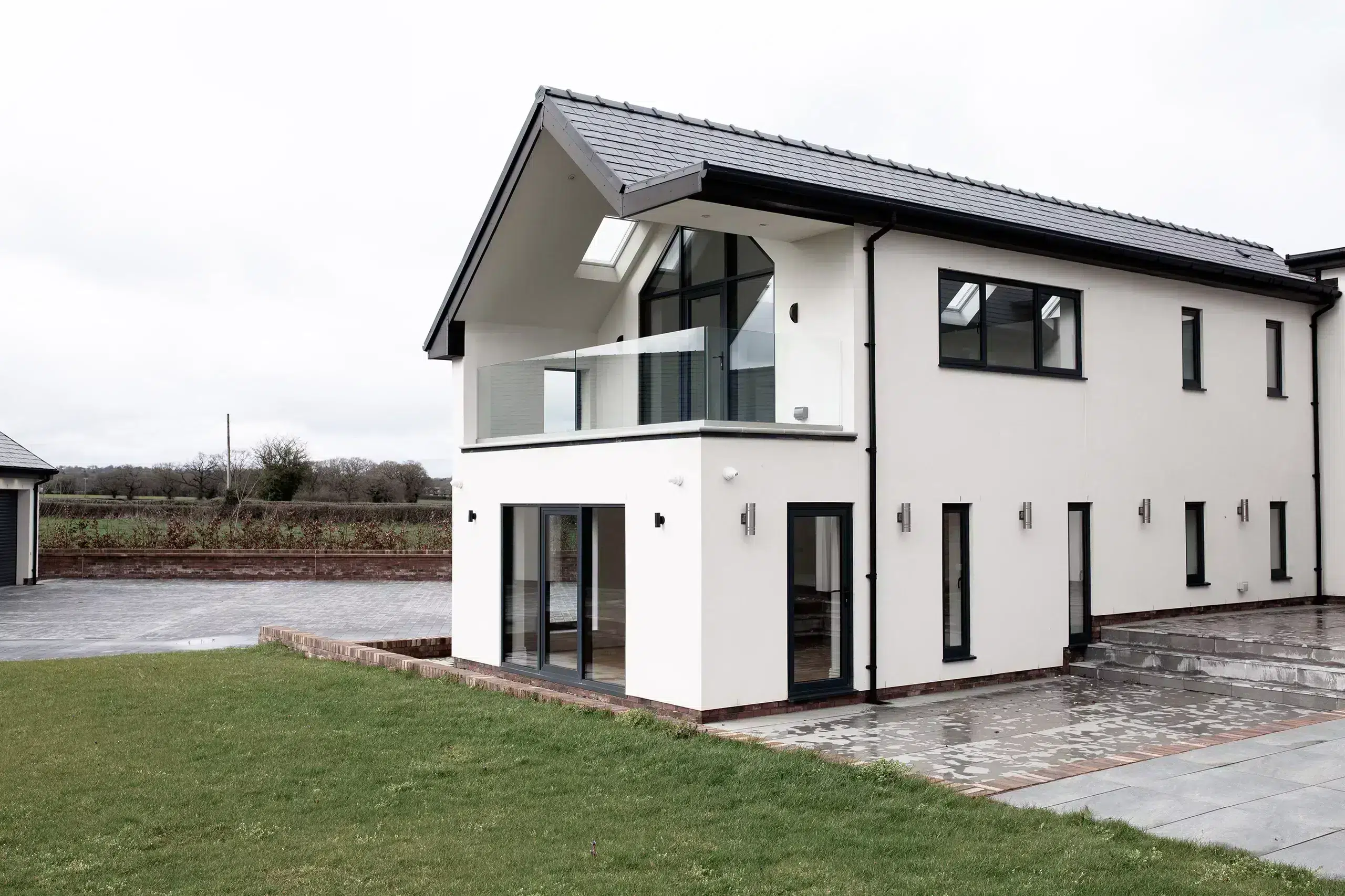 Witte woning met glazen balkonbalustrade — ONLEVEL project Wrexham